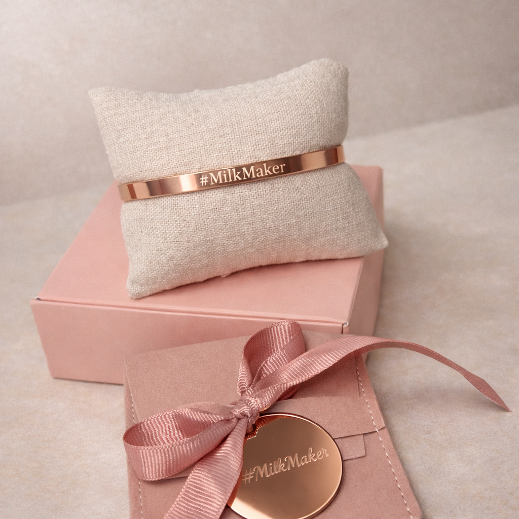 Rose gold bracelet with '#MilkMaker' branding on a textured pillow and pink box with a bow.