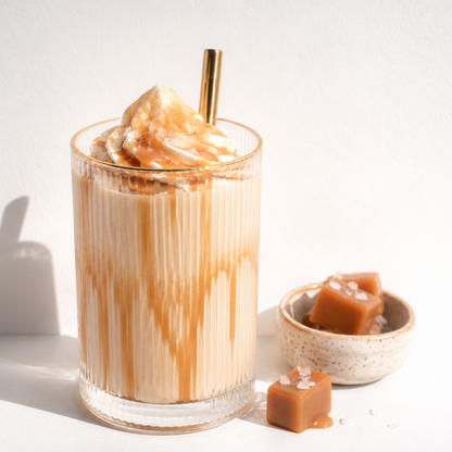 Glass of iced coffee with a scoop of ice cream and caramel sauce on a white background