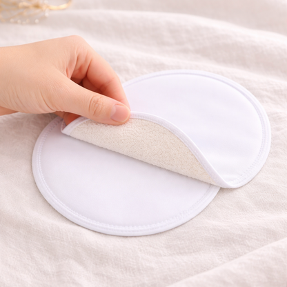 Hand holding a white cloth pad on a textured surface