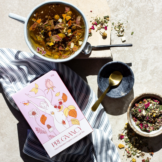 Tea-making setup with tea leaves, teacup, and tea package on a textured surface