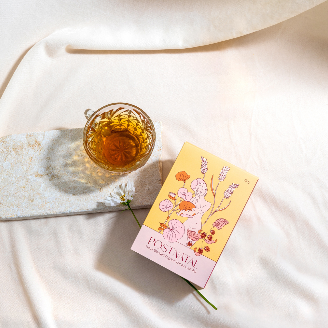 Tea cup and box on a white fabric background